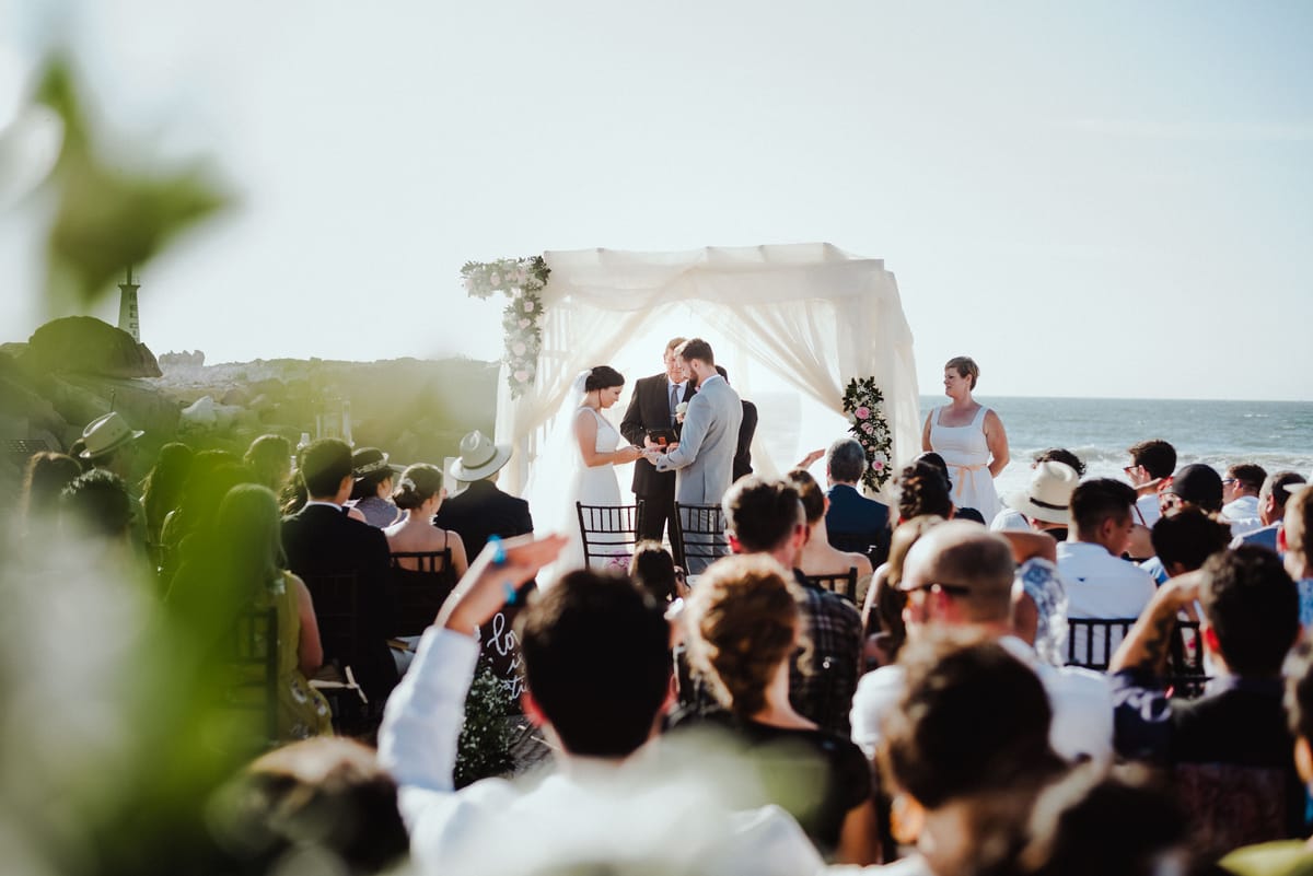 Ceremonia junto al mar vista desde atrás de los invitados