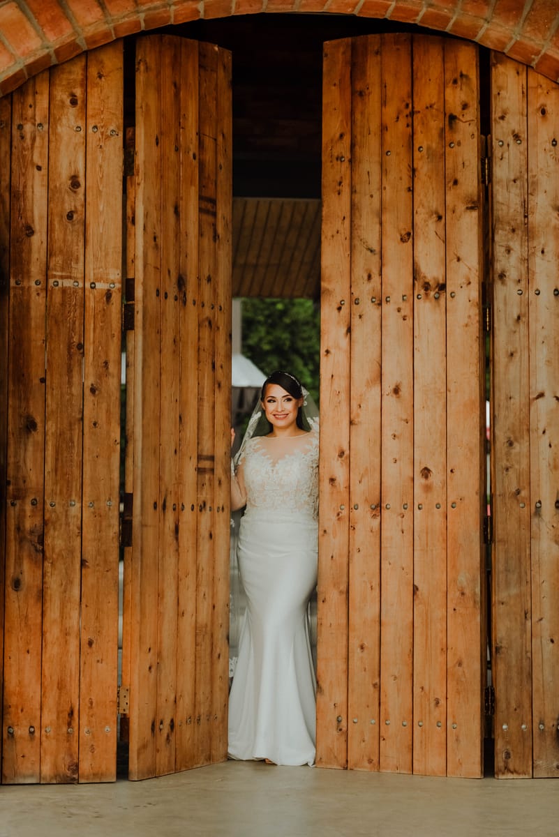 La novia aparece entre dos grandes puertas de madera