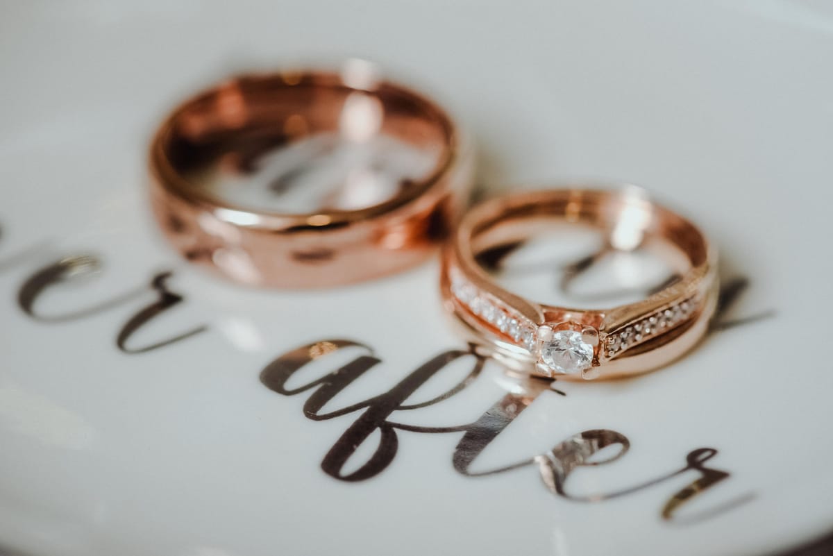Dos anillos de oro rosa sobre un plato con letras