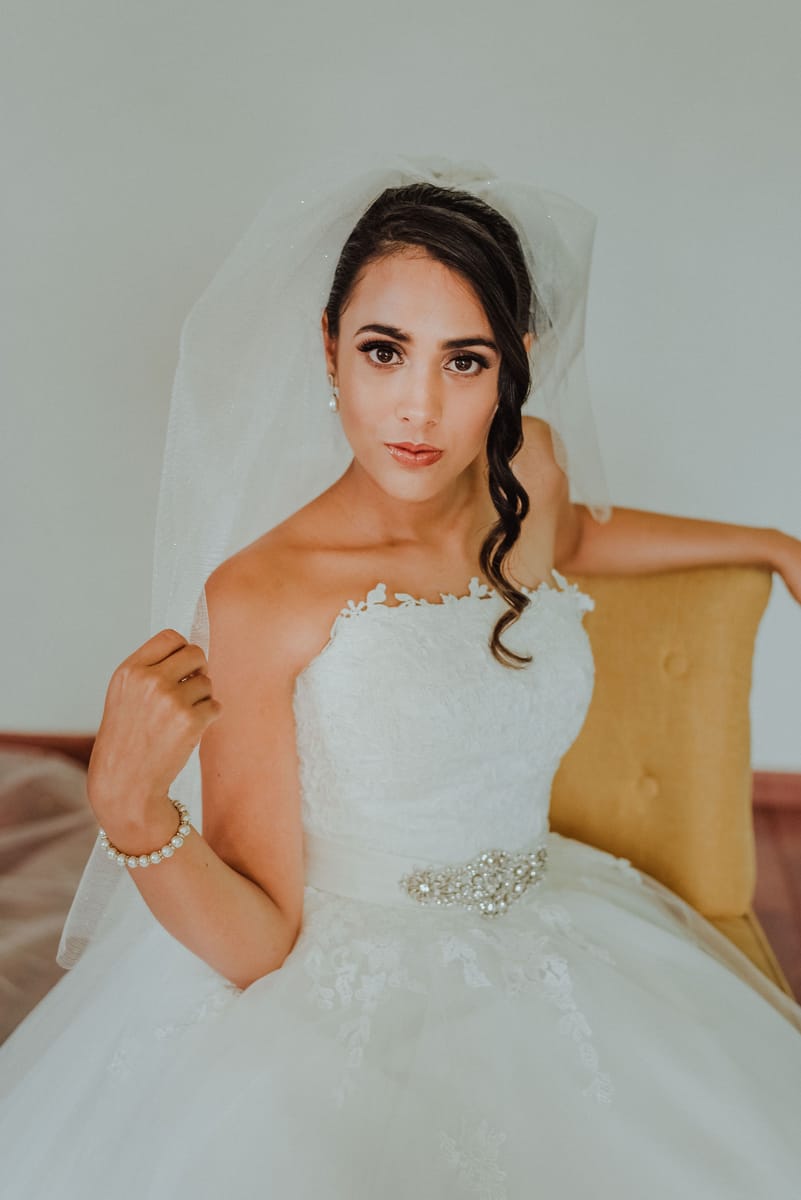 Retrato de la novia sentada, con velo corto y la mirada al frente