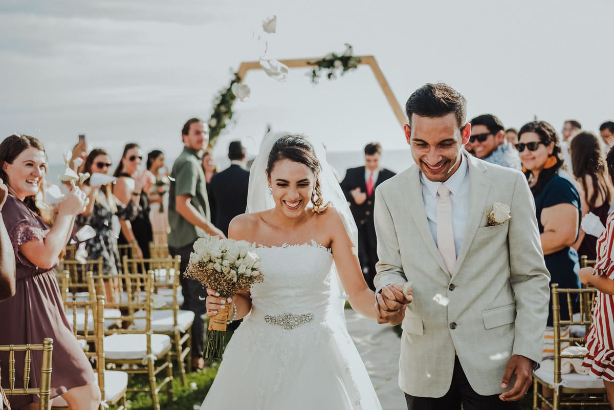 Los novios salen riendo entre los invitados después de la ceremonia