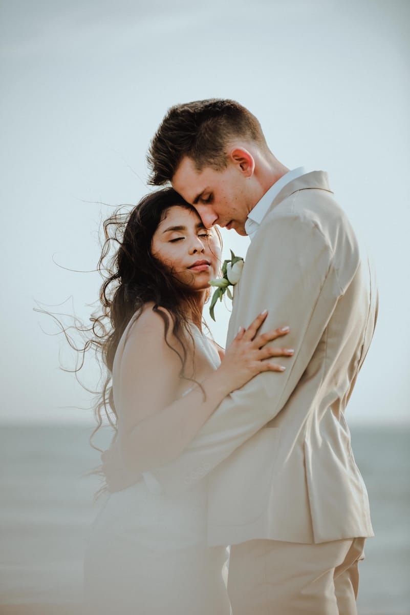 Retrato de pareja abrazada, con el viento en el cabello de la novia
