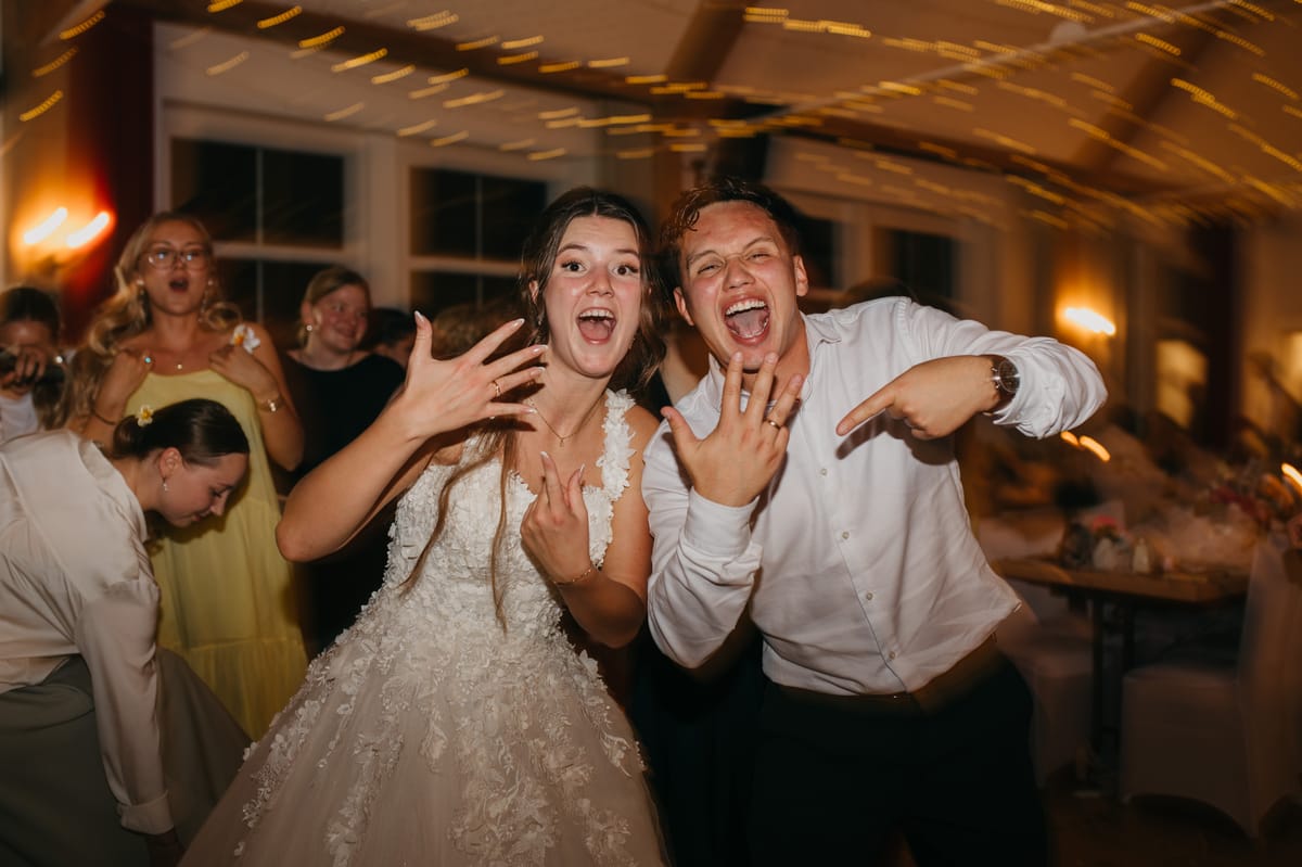 Los novios celebran y muestran sus anillos en la fiesta